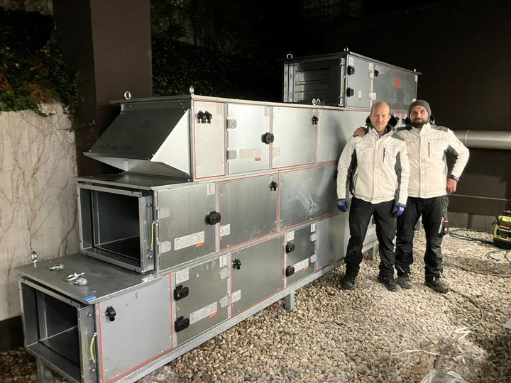 Montageteam vor einem fertig aufgestellten Lüftungsgerät