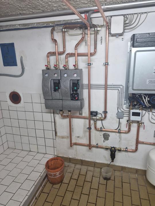 Heizraum mit Pumpengruppen, Kupferleitungen und Steuerung der Wärmepumpe